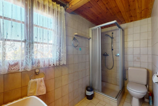salle de bains avec plafond de bois, carrelage, douche, et lumière naturelle