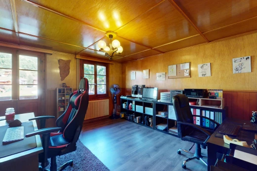 bureau avec lustre, plancher de bois, lumière naturelle, mur en bois, et radiateur