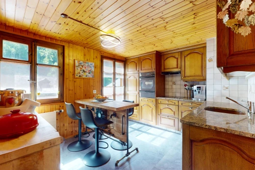 cuisine avec meubles à panneaux en relief, plafond de bois, crédence, lumière naturelle, et meubles arqués