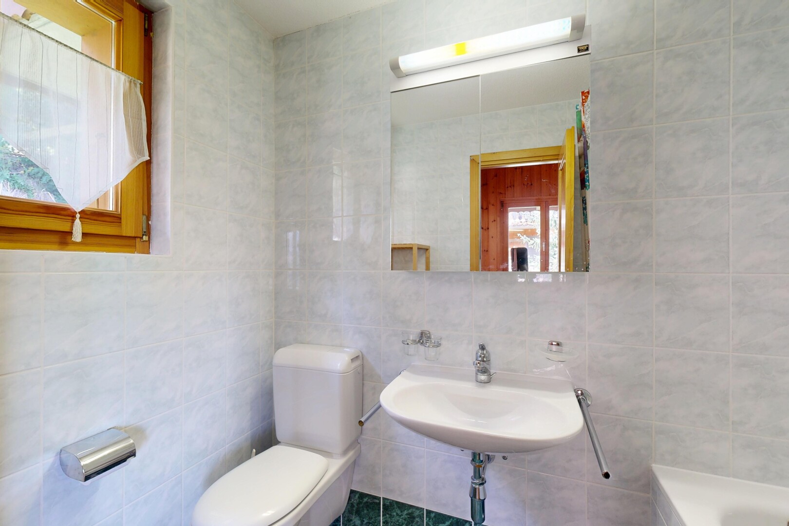 salle de bains avec tile wall, mur en carrelage, miroir, toilette, et salle de bain complète