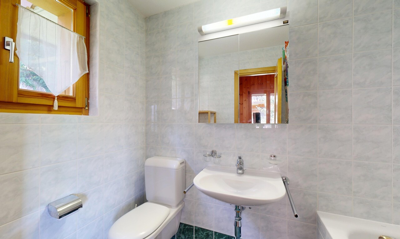 salle de bains avec tile wall, mur en carrelage, miroir, toilette, et salle de bain complète