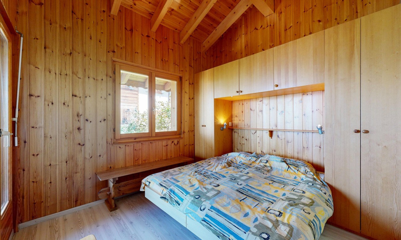 chambre avec vaulted ceiling, plafond voûté, beamed ceiling, plafond à poutres, et wood wall