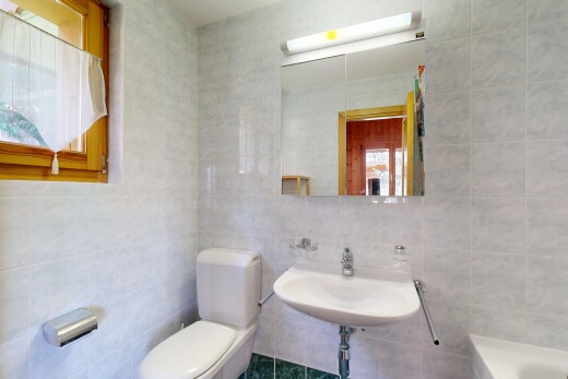 salle de bains avec tile wall, mur en carrelage, miroir, toilette, et salle de bain complète