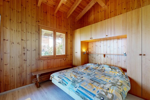 chambre avec vaulted ceiling, plafond voûté, beamed ceiling, plafond à poutres, et wood wall