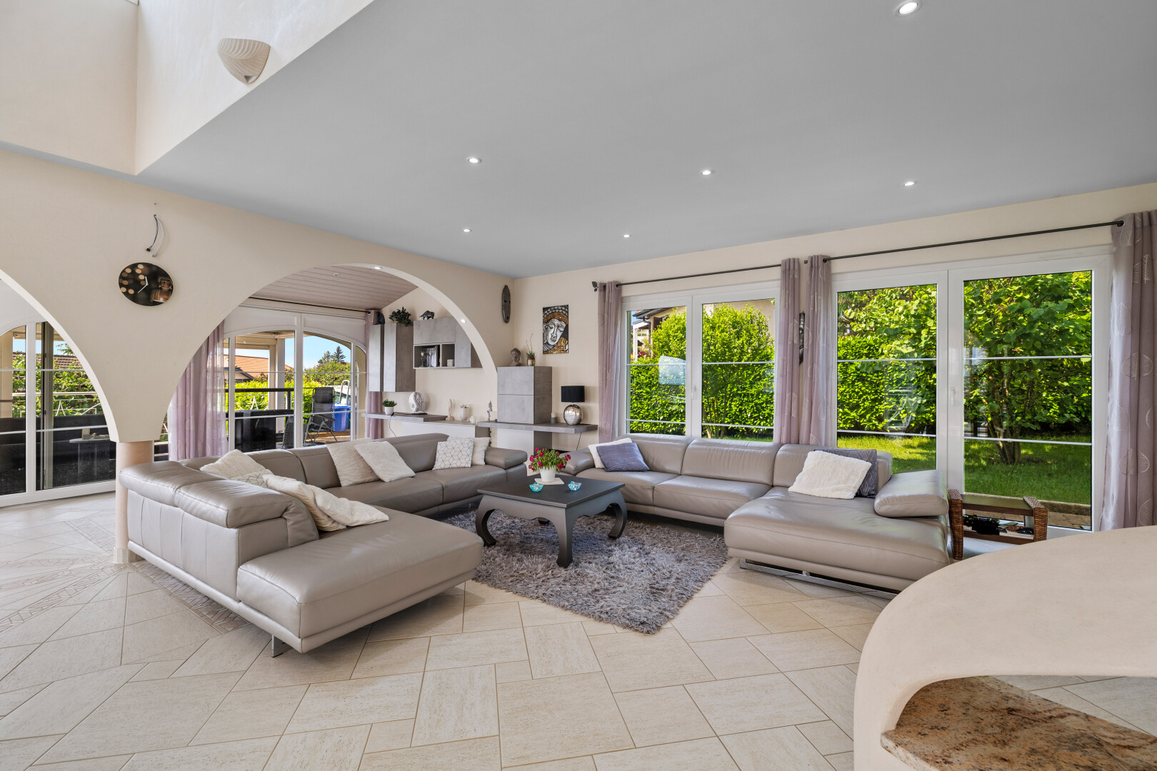 tiled living area with plenty of natural light, arched walkways, and recessed lighting