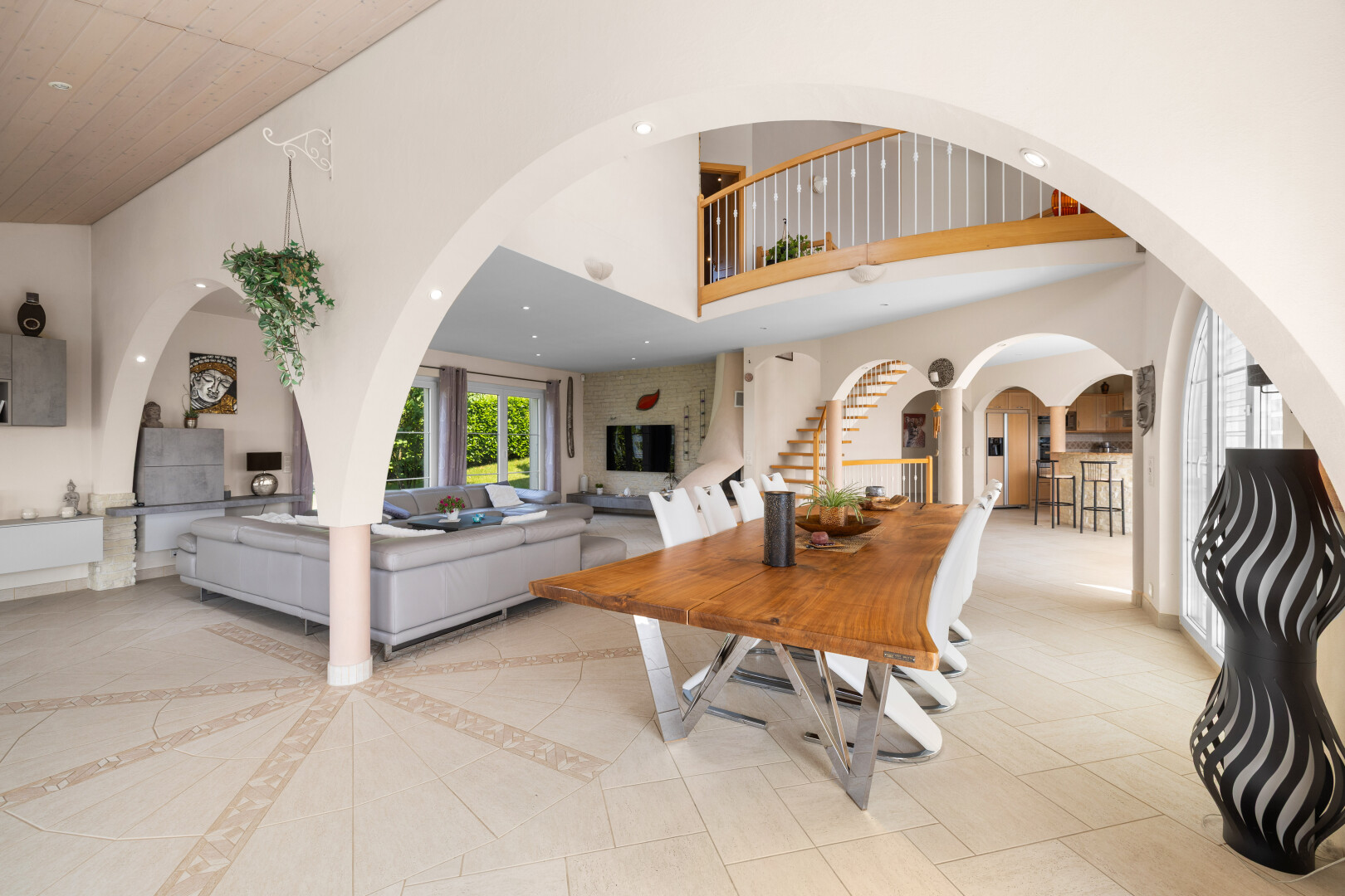 dining room featuring a towering ceiling, stairway, and arched walkways