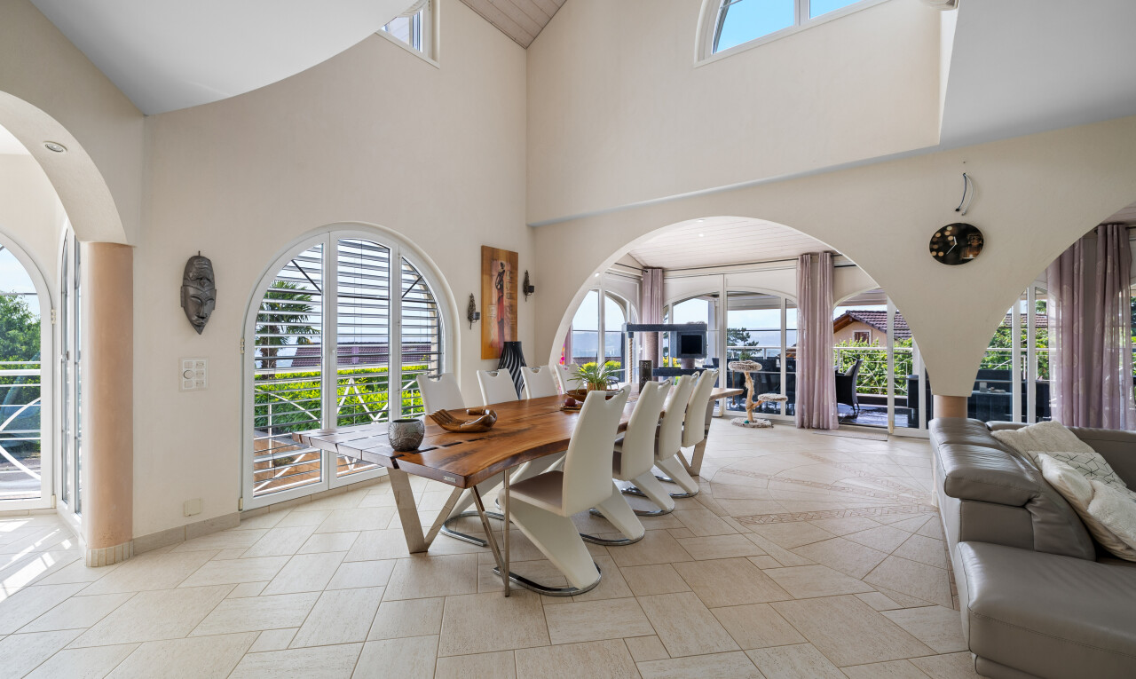 dining space with high vaulted ceiling and baseboards
