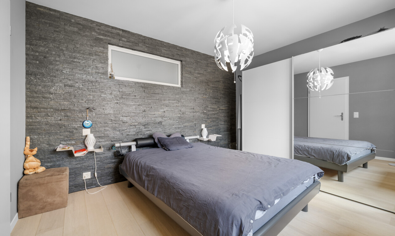room with a chandelier, billiards table, wood finished floors, and an accent wall