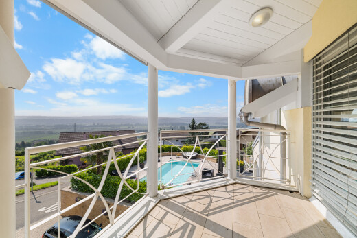 balcony featuring view of pool area and a sunroom