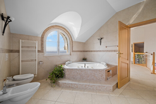 full bath featuring radiator, tile patterned floors, tile walls, a jetted tub, and a bidet