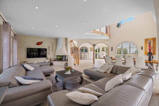 living area featuring recessed lighting, a glass covered fireplace, a high ceiling, and tile patterned flooring