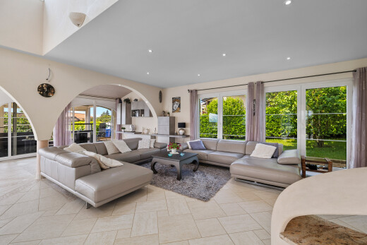 tiled living area with plenty of natural light, arched walkways, and recessed lighting
