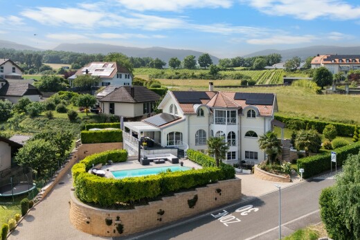 view of property featuring a mountain view, roof mounted solar panels, and an outdoor pool