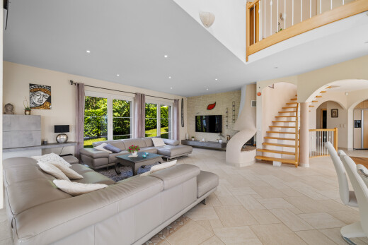 living area with arched walkways, stairway, and recessed lighting