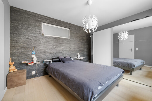 room with a chandelier, billiards table, wood finished floors, and an accent wall