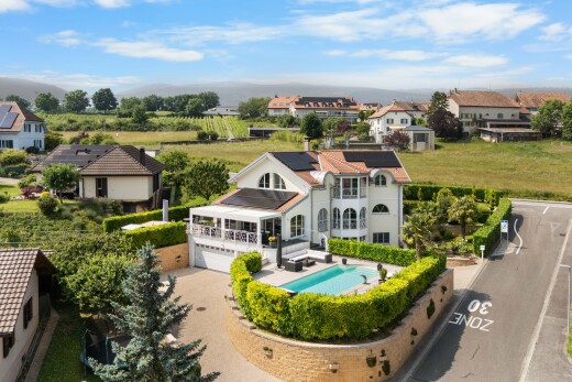 view of home featuring roof mounted solar panels, an outdoor pool, and driveway