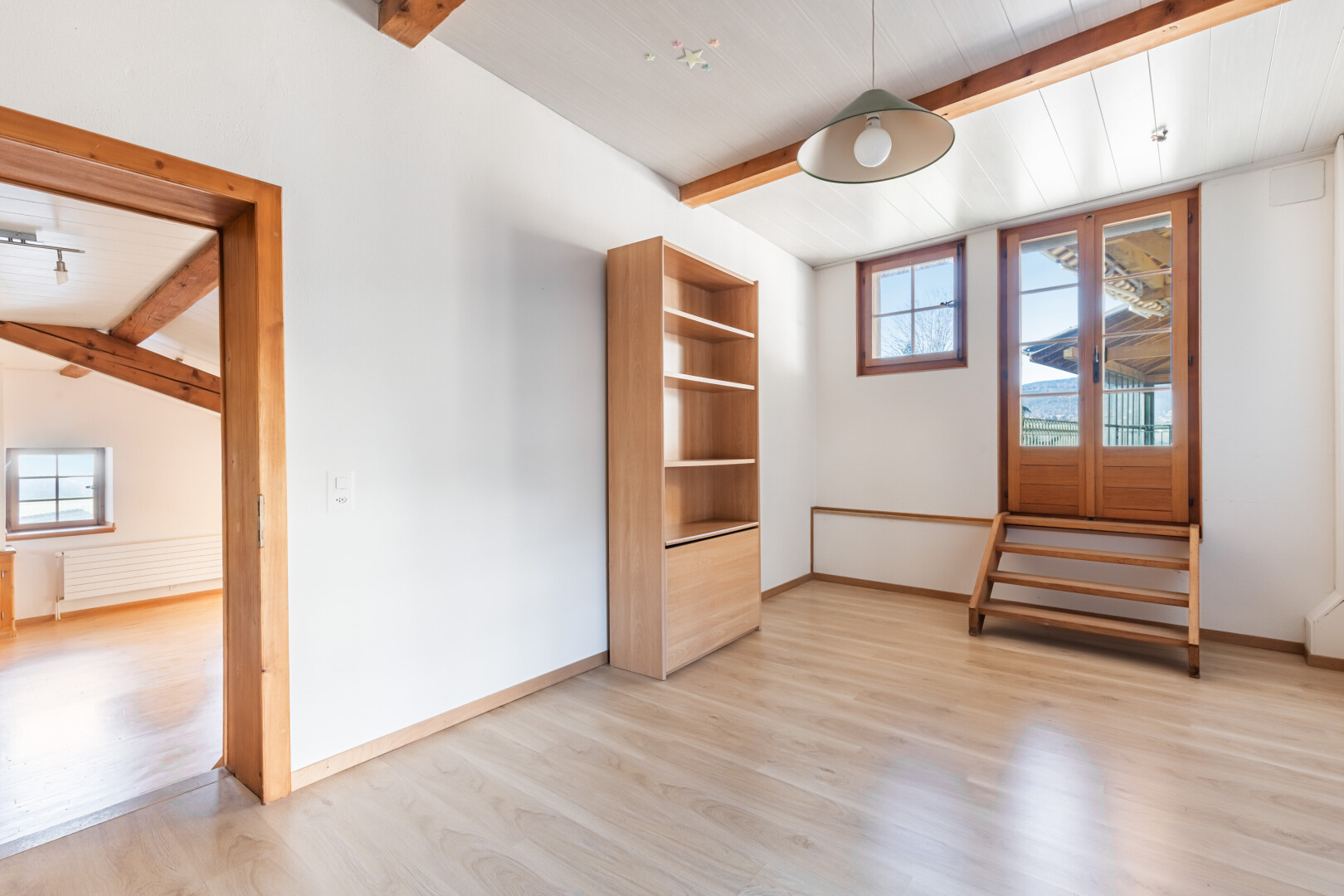 pièce vide avec plafond à poutres, beamed ceiling, lumière naturelle, natural light, et sol en finition bois