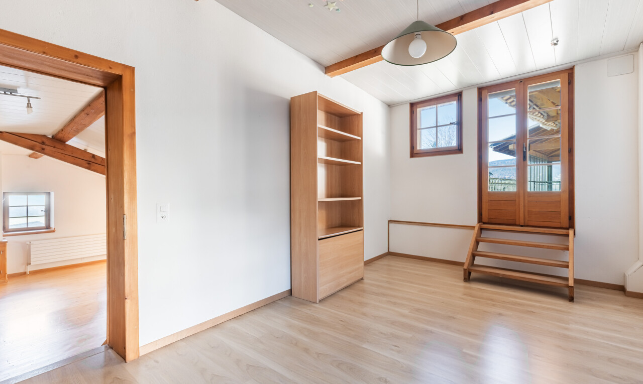 pièce vide avec plafond à poutres, beamed ceiling, lumière naturelle, natural light, et sol en finition bois