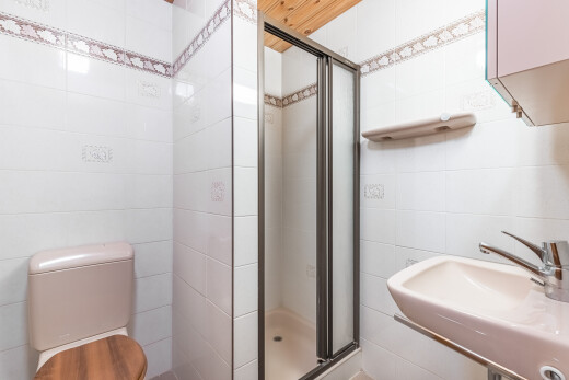 salle de bains avec toilette, douche, salle de bain complète, évier, et tile wall