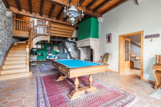 salon avec plafond haut, high ceiling, escaliers, billard, et stone wall