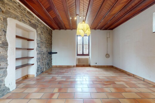 pièce vide avec radiateur, mur en pierre, lumière naturelle, et étagères intégrées
