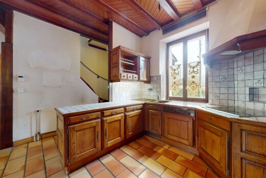 cuisine avec lumière naturelle, cuisinière, plan de travail en carrelage, péninsule de cuisine, et meubles marron moyen