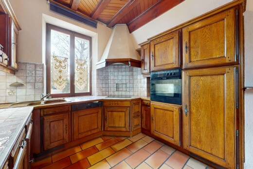 cuisine avec plan de travail en carrelage, meubles marron moyen, hotte, et four