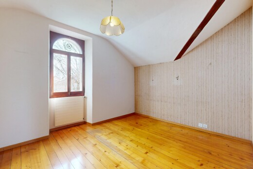 pièce vide avec plafond bas, plancher de bois, plafond voûté, et lumière naturelle