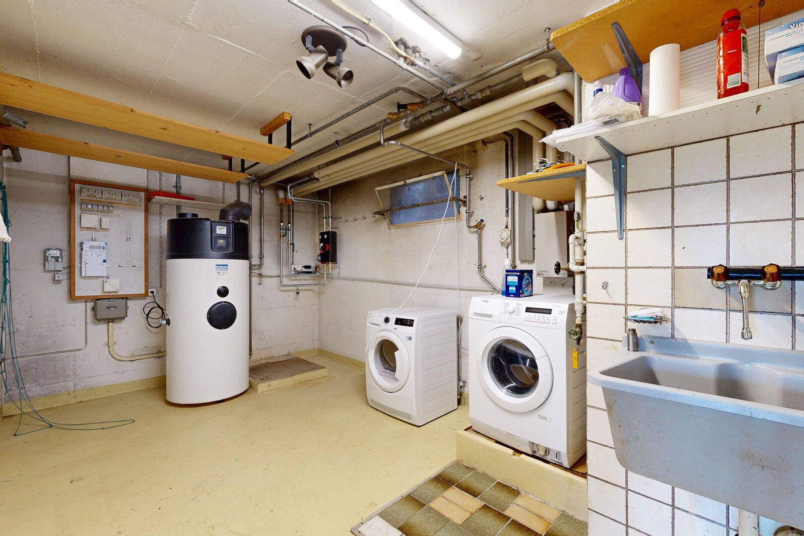 wäschekammer mit inside property, tumbler, waschbecken, betonboden, und concrete floor