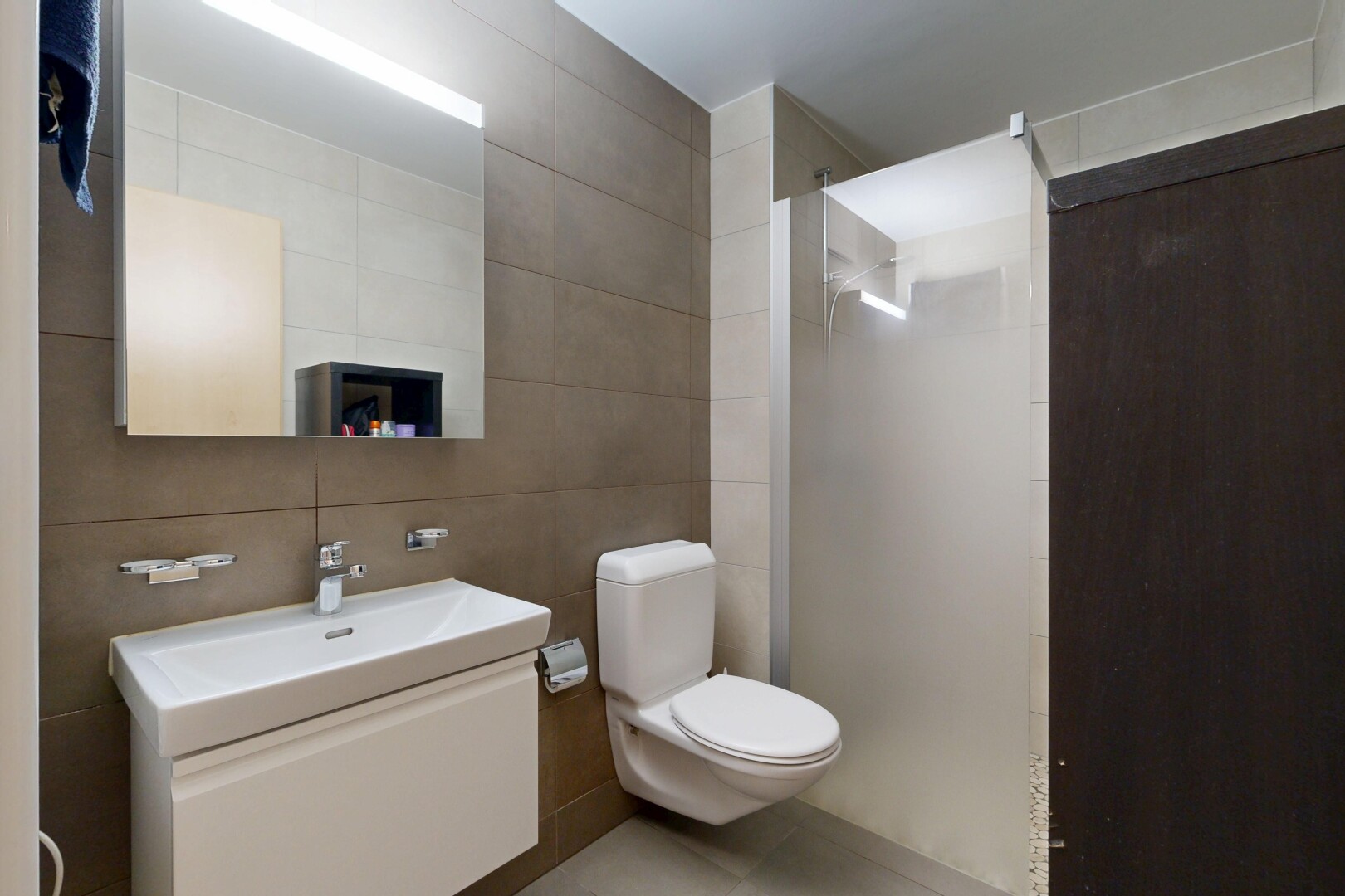 full bathroom featuring tile walls, vanity, and a walk in shower