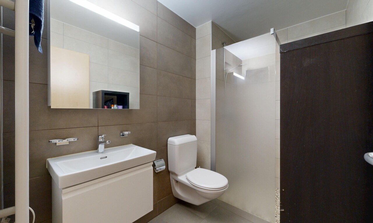 full bathroom featuring tile walls, vanity, and a walk in shower