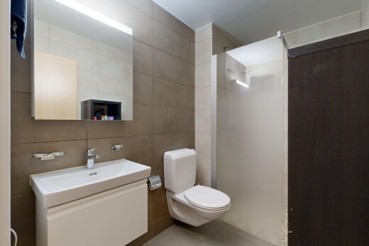full bathroom featuring tile walls, vanity, and a walk in shower
