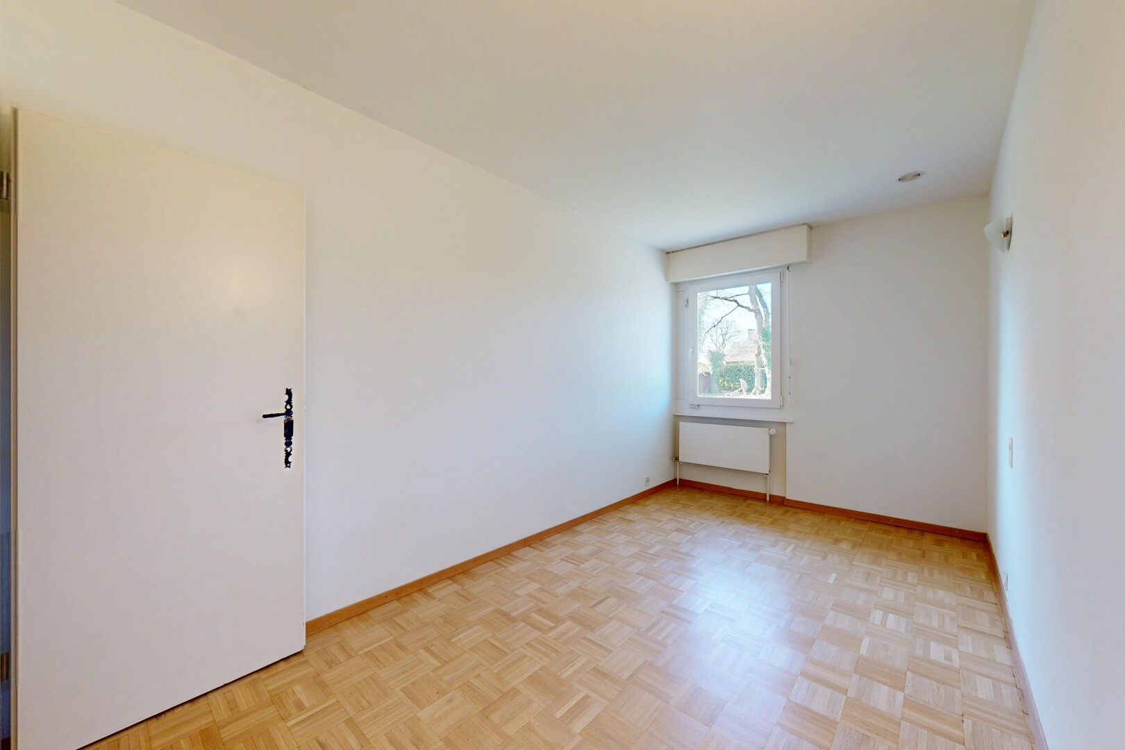 pièce vide avec plinthes murales, radiateur, lumière naturelle, et cloison sèche