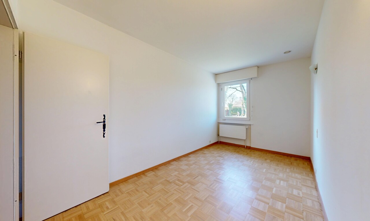 pièce vide avec plinthes murales, radiateur, lumière naturelle, et cloison sèche