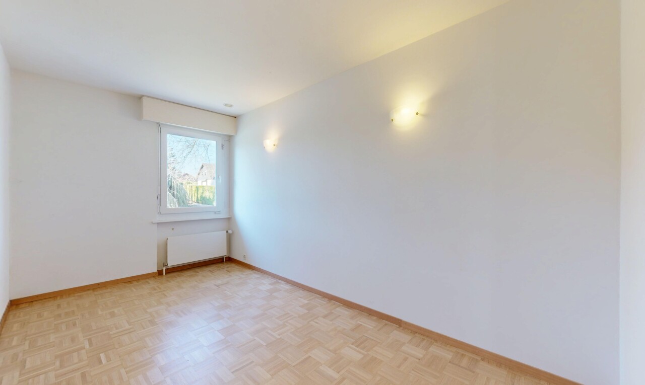 pièce vide avec plinthes murales, radiateur, cloison sèche, et lumière naturelle