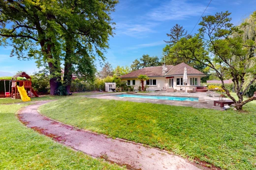 façade avec piscine, aire de jeux, terrasse, et pelouse