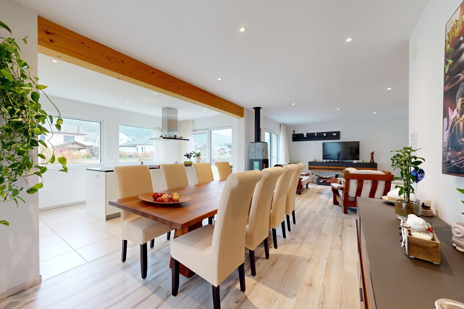 wohn- / esszimmer mit balkendecke, beamed ceiling, holzofen, gipskartonwand, und drywall