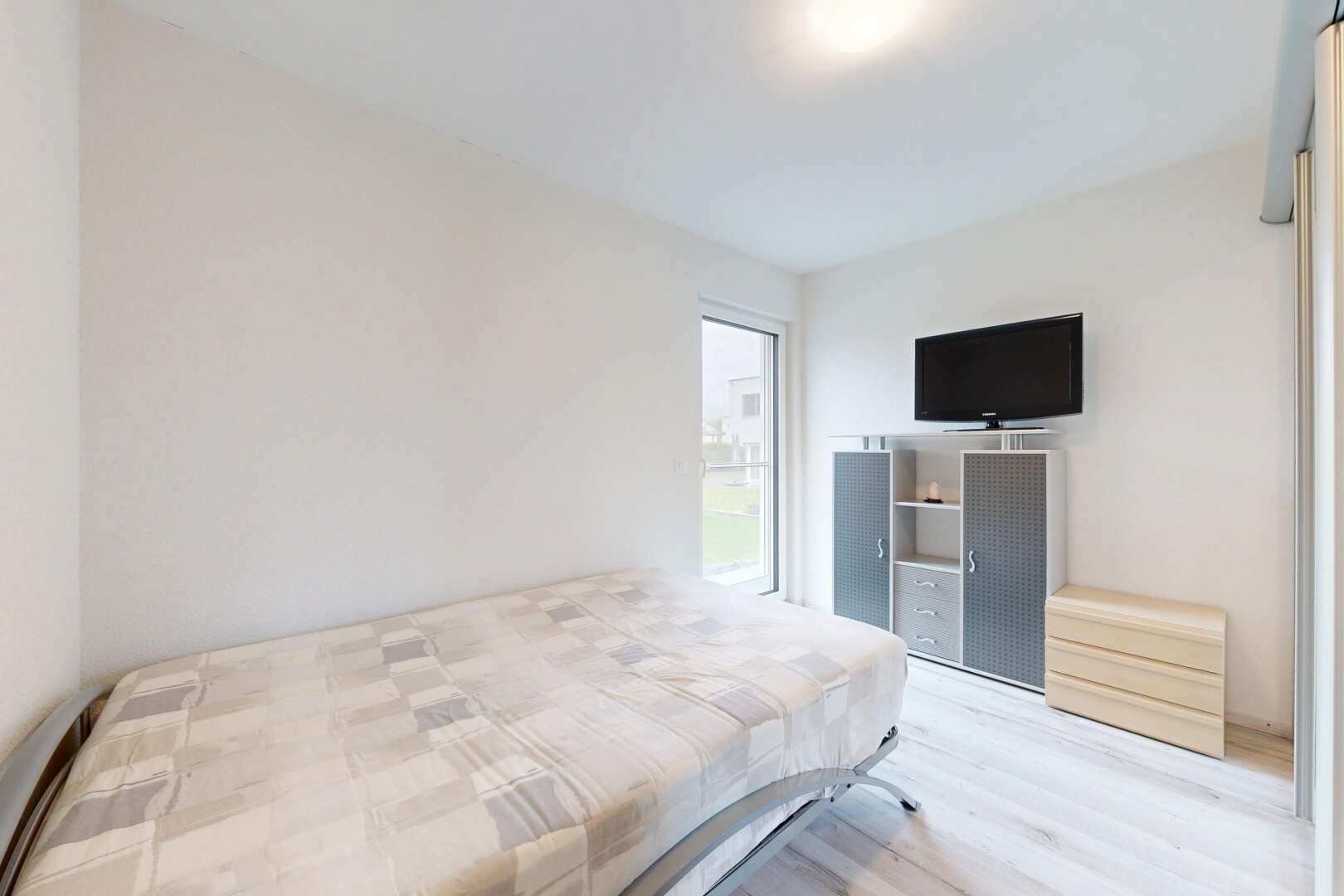 zimmer / schlafzimmer mit inside property, fernseher, gipskartonwand, drywall, und holzfußboden