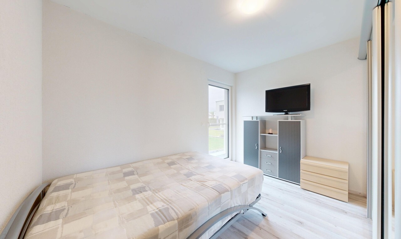 zimmer / schlafzimmer mit inside property, fernseher, gipskartonwand, drywall, und holzfußboden