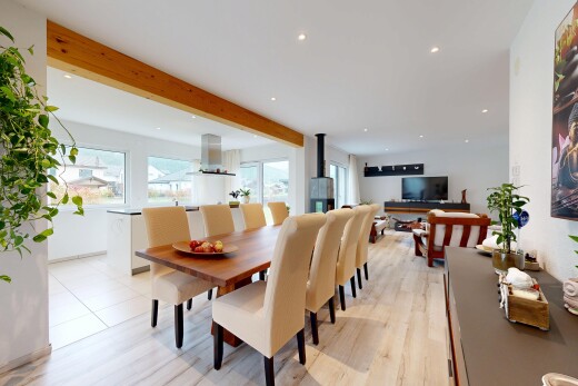 wohn- / esszimmer mit balkendecke, beamed ceiling, holzofen, gipskartonwand, und drywall