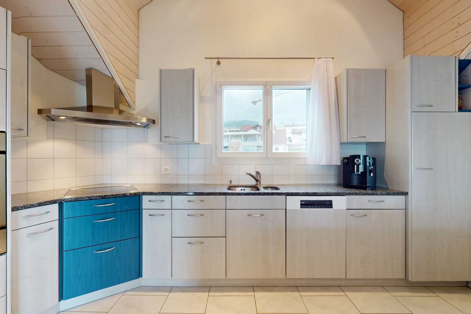 cuisine avec crédence, plan de travail en pierre, carrelage, vasque, et lumière naturelle