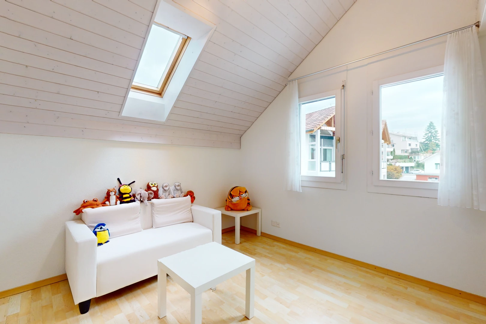 salon avec plancher de bois, lucarne, plafond voûté, lumière naturelle, et plafond bas