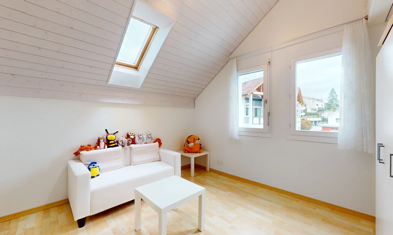 salon avec plancher de bois, lucarne, plafond voûté, lumière naturelle, et plafond bas