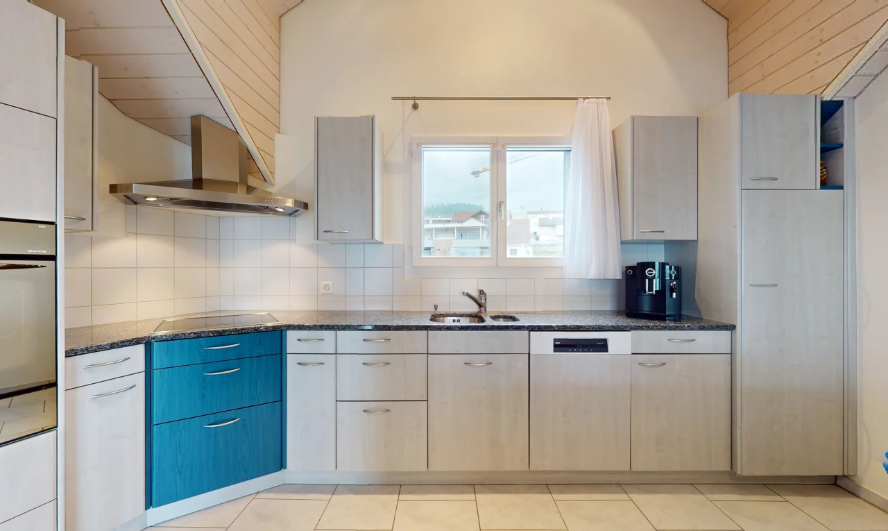 cuisine avec crédence, plan de travail en pierre, carrelage, vasque, et lumière naturelle