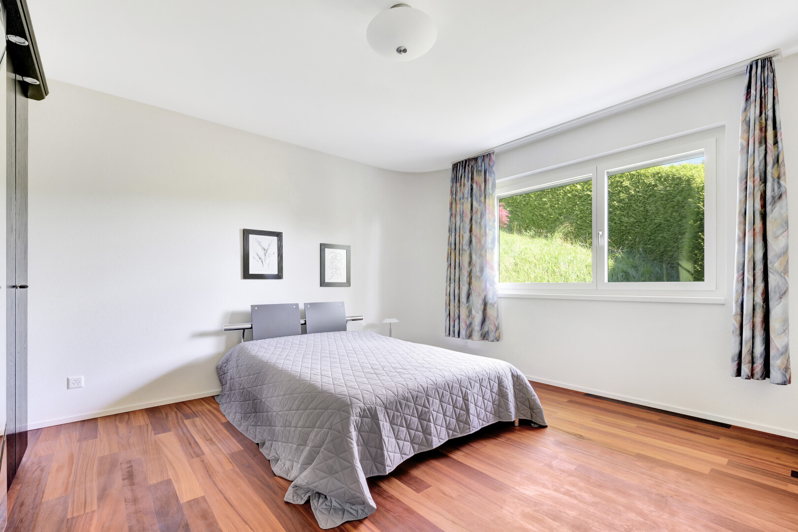 zimmer / schlafzimmer mit natural light, natürliches licht, drywall, gipskartonwand, und wood finish floor
