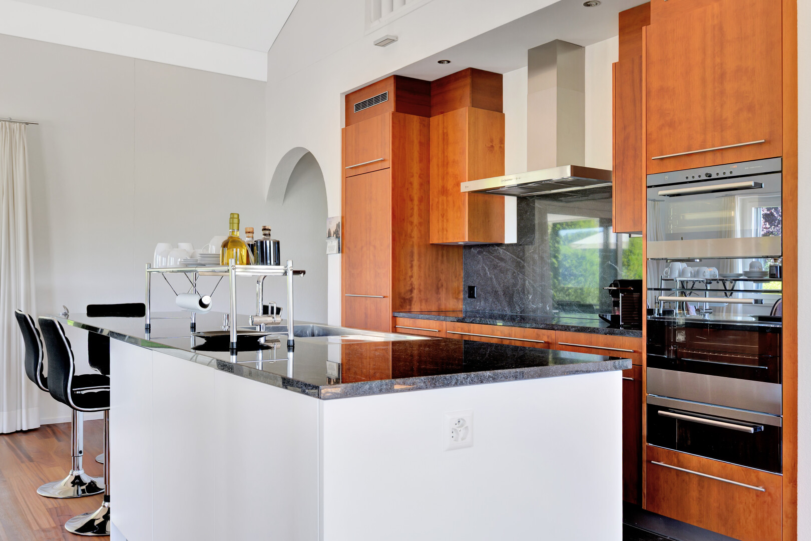 küche mit schränke mit flachen paneelen, kücheninsel, dunstabzugshaube, stein arbeitsplatten, und inside property