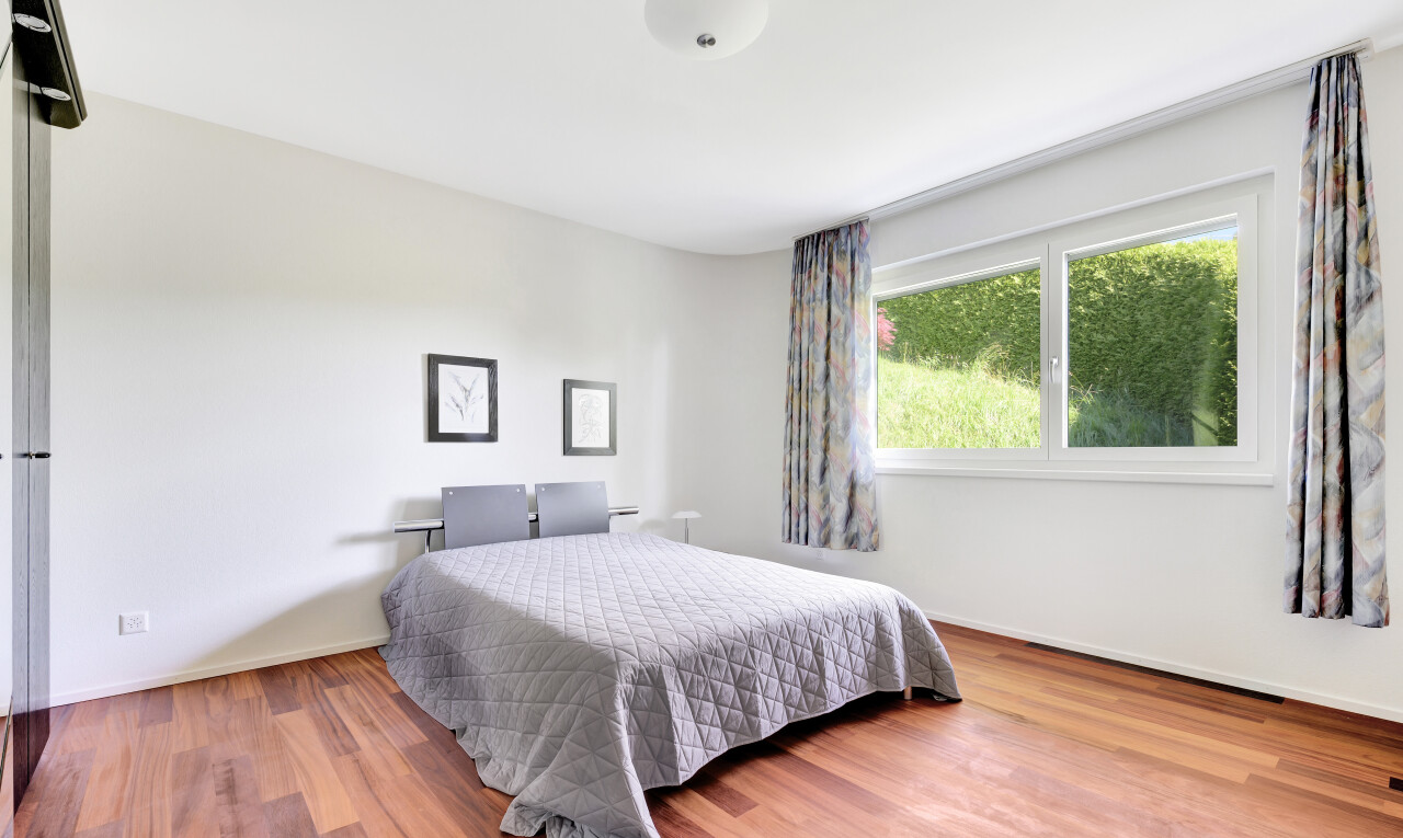 zimmer / schlafzimmer mit natural light, natürliches licht, drywall, gipskartonwand, und wood finish floor