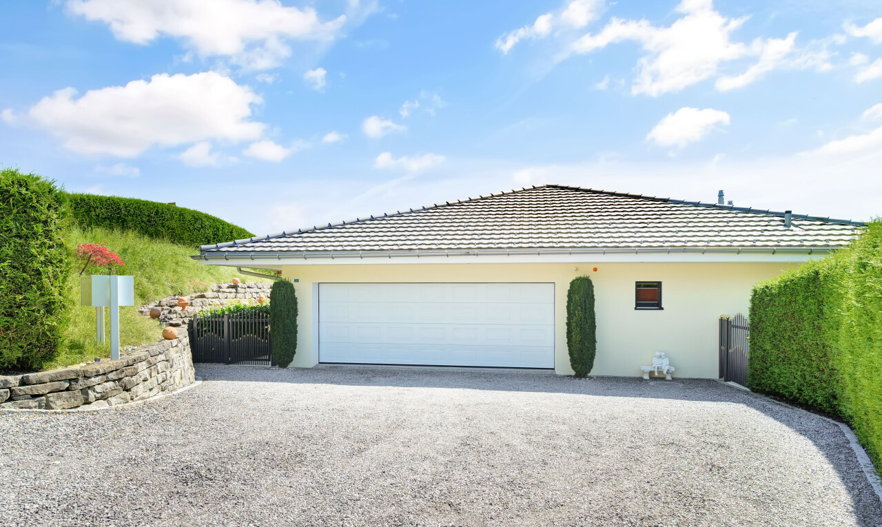 außenansicht mit auffahrt, zaun, property visible, stuckverkleidung, und day time