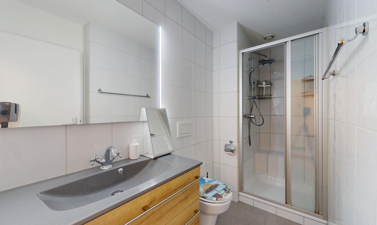 bad mit komplettes badezimmer, dusche, toilette, schminktisch, und tile wall