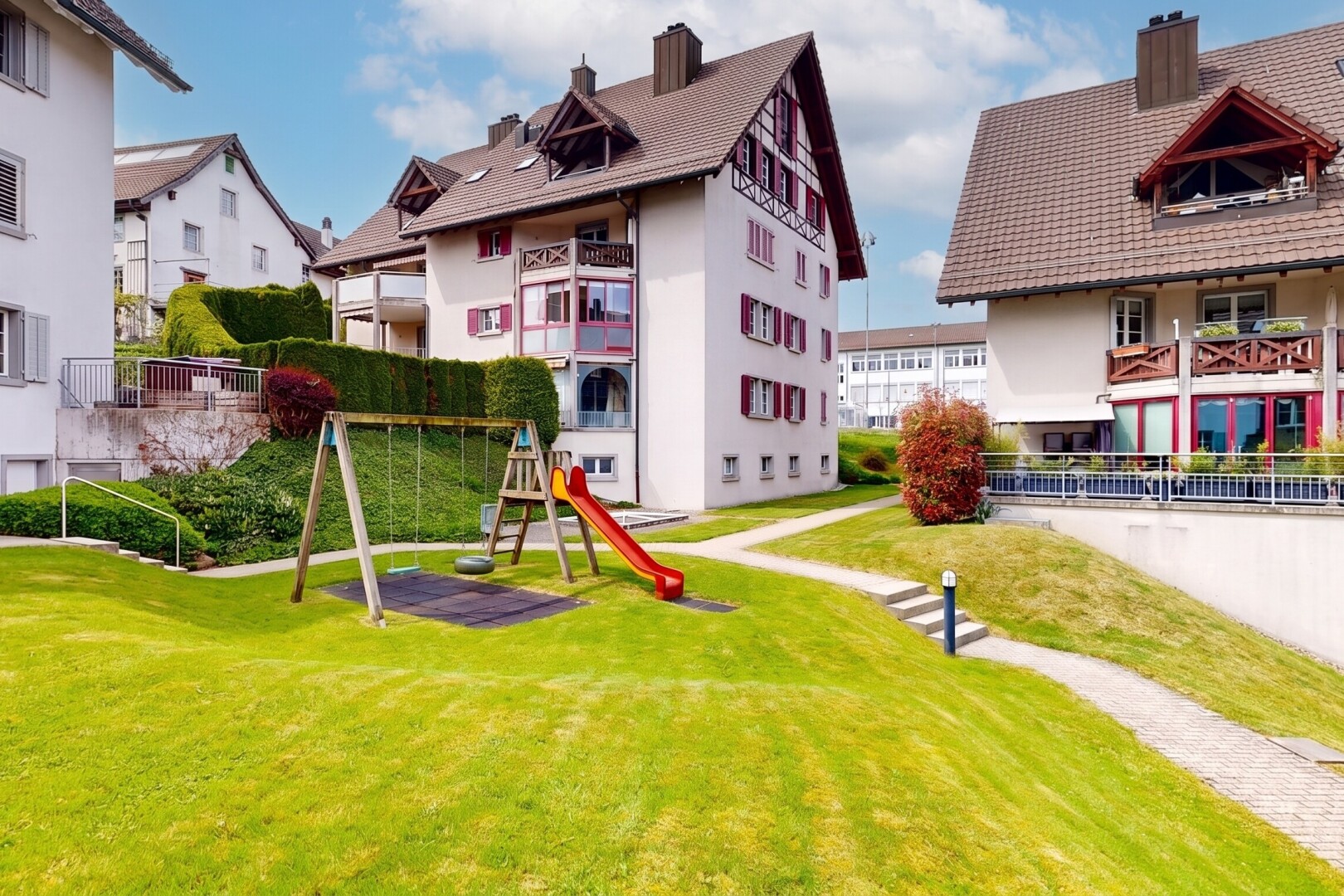 außenansicht mit schornstein, day time, spielplatz, rasen, und stuckverkleidung
